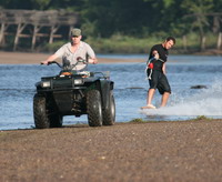 image: Andrew Black ridin' behind his ATV along the river banks just up from downtown Tulsa